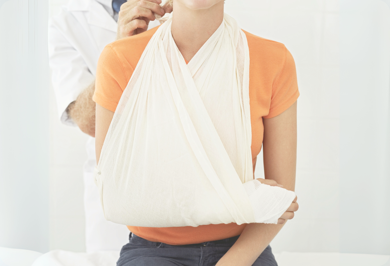 Clothes to wear with broken shoulder: Woman in a doctor’s office wearing a sling for her broken shoulder