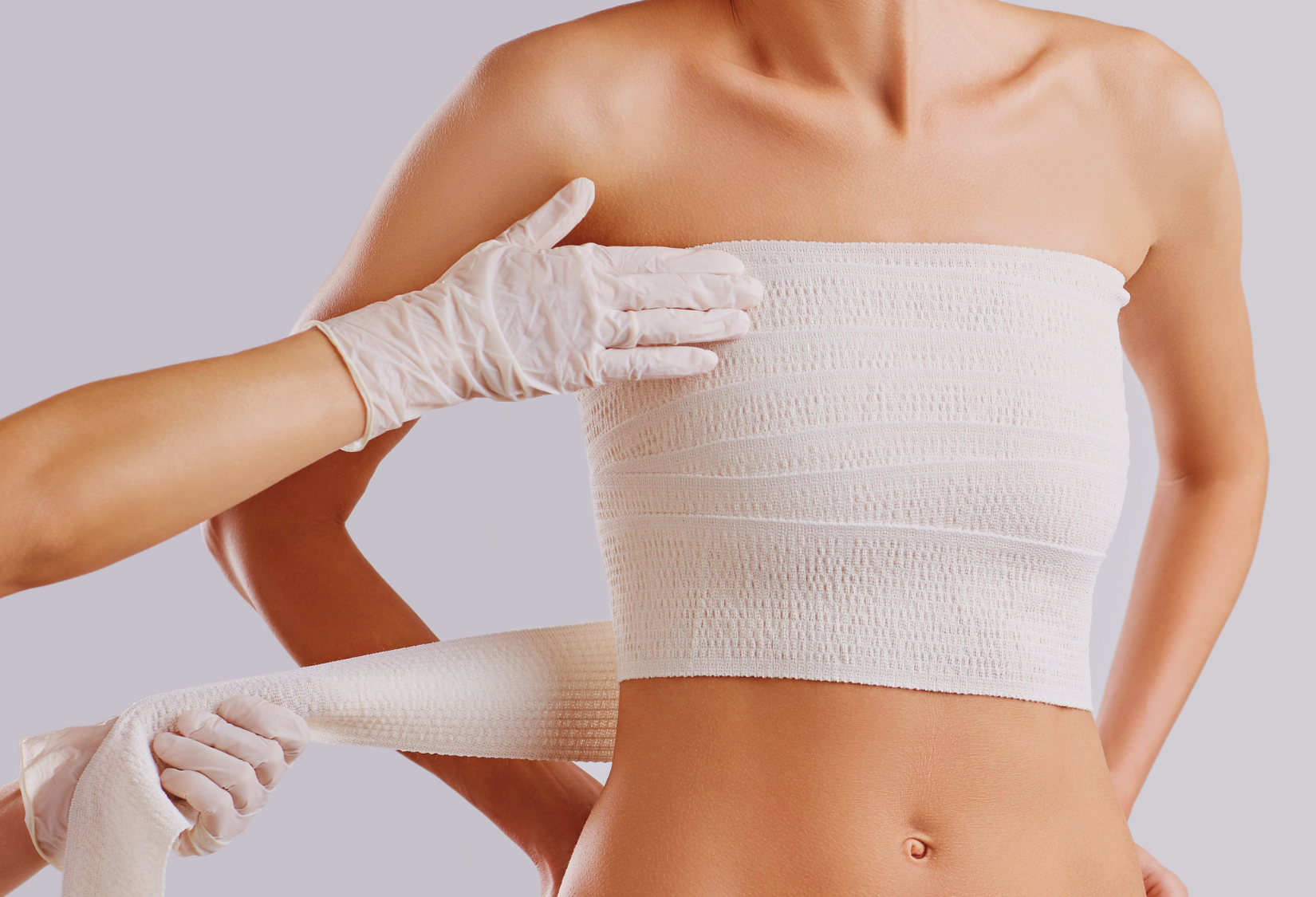 Women recovering from breast surgery with a nurse tightening up her bandage