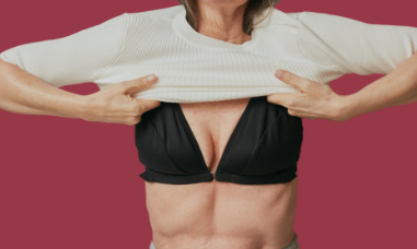 Mature woman pulling down a white sweater over the front closing bras for seniors designed to be a bra for arthritis